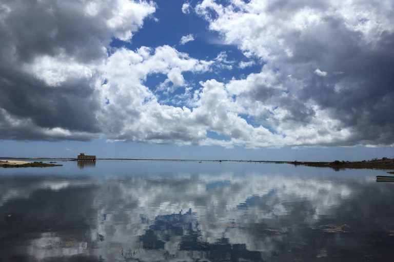A photo of the abandoned lifeboat station in Fuseta, with clouds reflected onto the sea