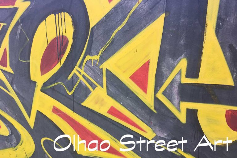 A Photo of Olhao Street Art - black, red and yellow shapes