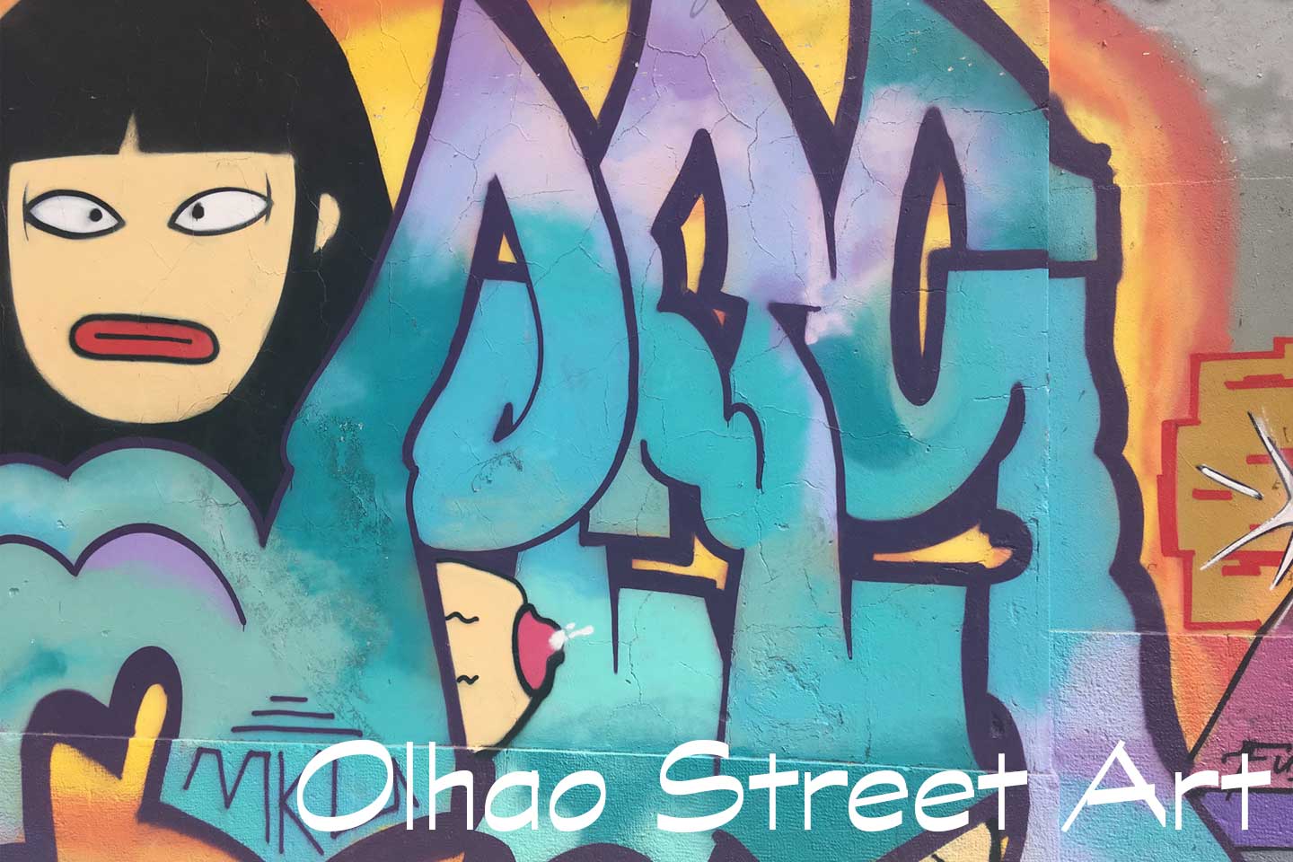 A Photo of Olhao Street Art - A cartoon face of a girl and a greeny blue tag