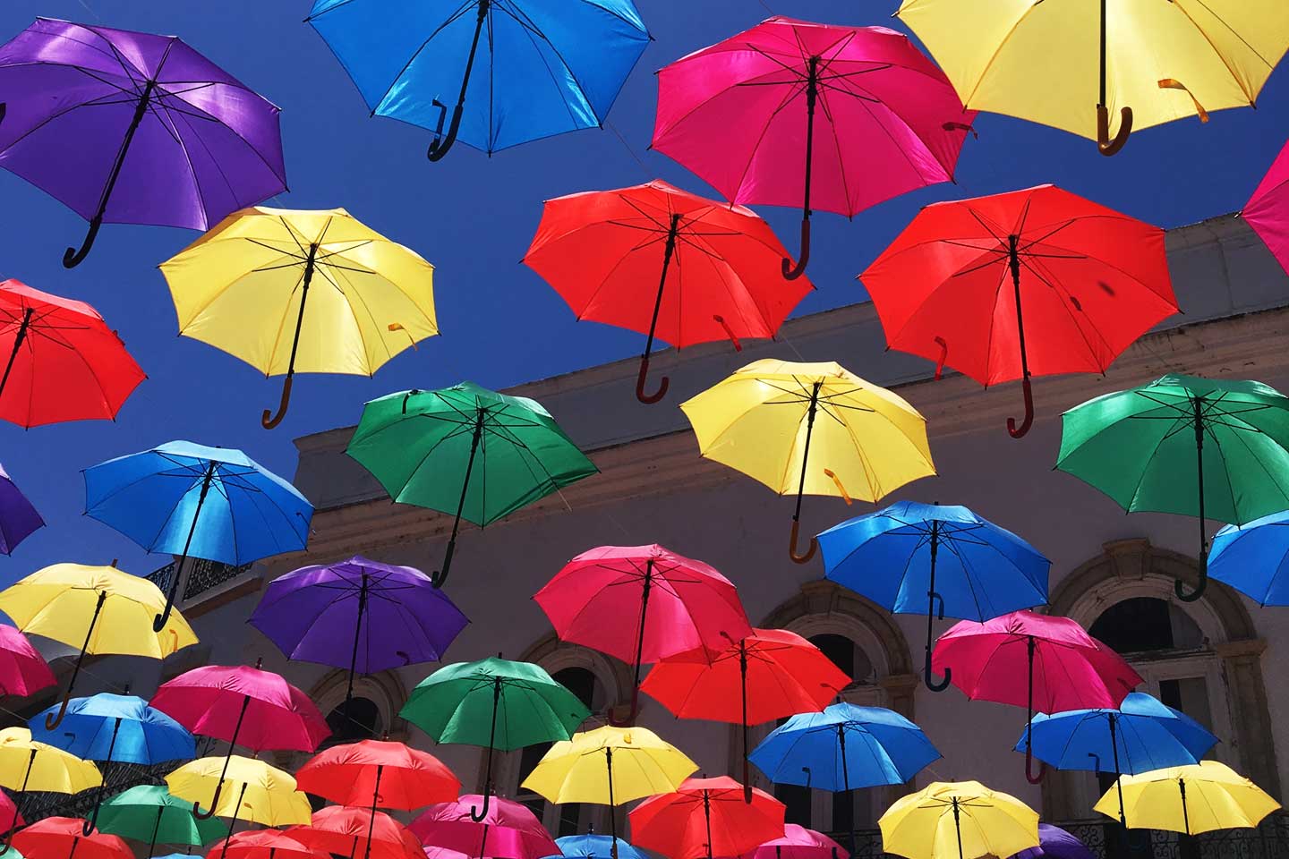 Colourful umbrellas decorate the streets of Olhao in the Eastern Algarve, home of Blinking Flamingos