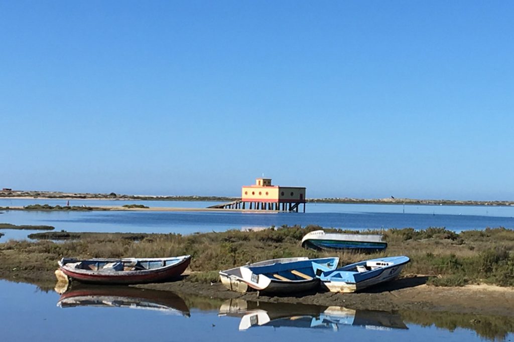 The abandoned Lifeboat Station in Fuseta with five small fishing boats lying in front of it