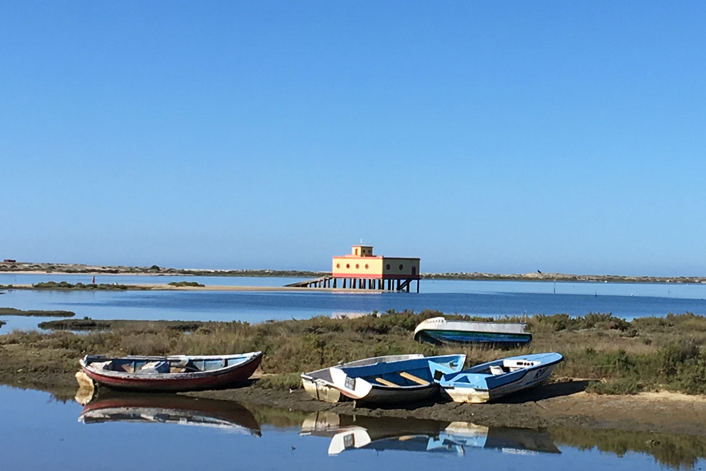 The abandoned Lifeboat Station in Fuseta with five small fishing boats lying in front of it