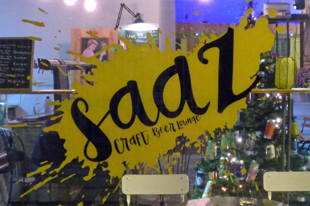 A Photo of Saaz Bar's logo on the window - in Olhao, after dark