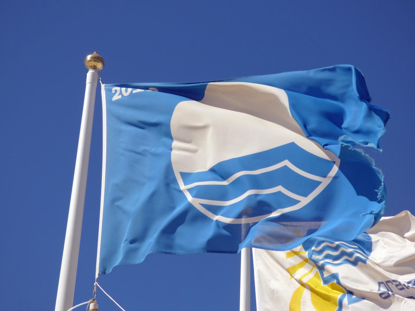 A photo of blue sky and flags in Fuseta