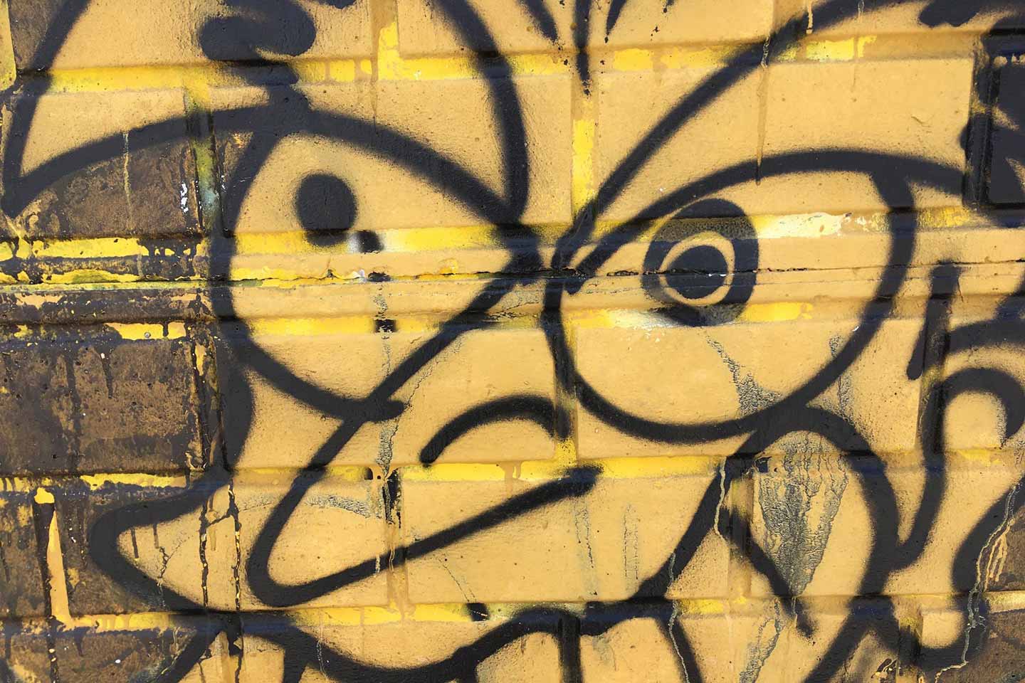 Olhao Street Art - a black and yellow face